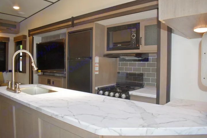 This RV rental boasts a full kitchen with a stylish marble-look island, sink, stove, microwave, and refrigerator.. Other Hideout 2021