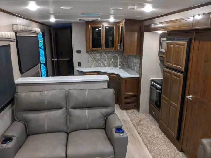 Modern RV rental interior: well-equipped kitchen, cozy living area with recliners, and stylish wood cabinetry.. Forest River Forest River Flagstaff Classic Super Lite 2021