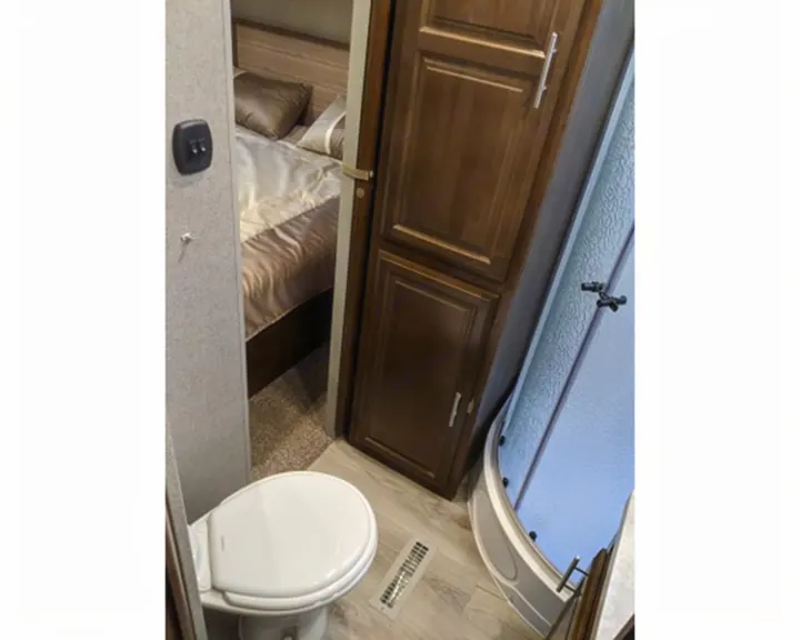 Explore this RV rental's compact interior: a bathroom with toilet & shower, plus a peek into the cozy bedroom.. Forest River Forest River Flagstaff Classic Super Lite 2021