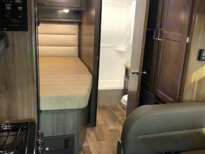 Cozy bed, compact kitchen, and bathroom with shower/toilet in an RV rental. Modern interior with storage & seating.. Winnebago Minnie Winnie 2020