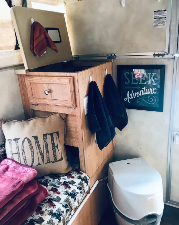 Cozy RV rental setup with clever storage, composting toilet, and "HOME" pillow for adventures.. Ford F250 2005