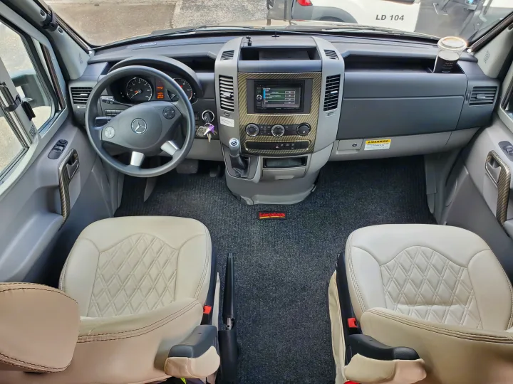 Inside this RV rental: Mercedes Sprinter cockpit with dash, infotainment, light seats, and Lazydays mat visible.. Wayfarer Wayfarer Motorhome 2017