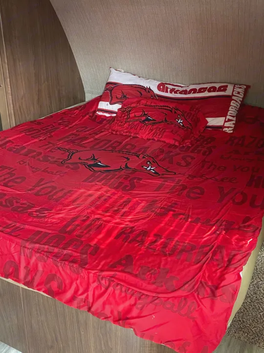 Arkansas Razorbacks themed bedding inside an RV rental, offering a cozy, fan-friendly travel space.. Dutchmen Aerolite 2017