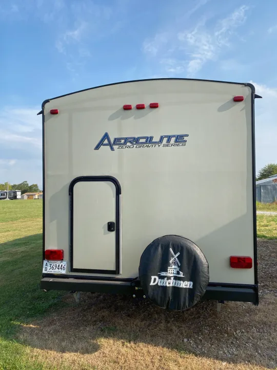 Rear of an Aerolite Zero Gravity travel trailer, an excellent rv rental. Features a light color, spare tire, and Arkansas license plate.. Dutchmen Aerolite 2017