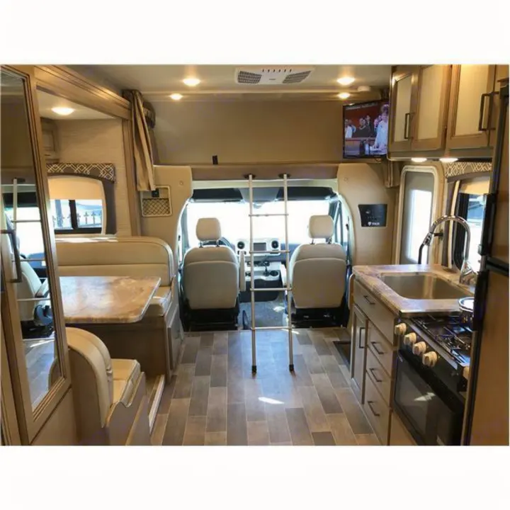 Full view of an rv rental interior: kitchen, dining area, front cockpit, and ladder leading to the over-cab bed.. Thor Motor Coach Chateau 2020