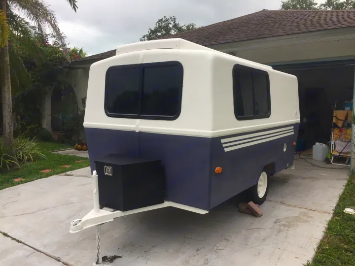 Compact, two-tone camper trailer, great for your next RV rental adventure, parked on a driveway.. Hunter Compact Junior 1971