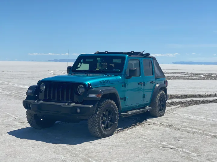 A striking teal Jeep Willys on a brilliant white salt flat. Experience adventure; an rv rental offers similar freedom for exploration.. Other Other 2020