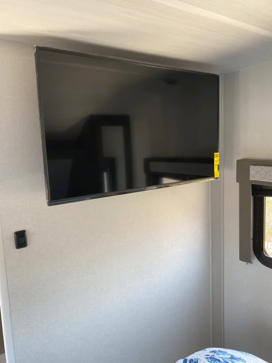 Enjoy entertainment in this RV rental! Wall-mounted VIZIO TV with energy guide, textured walls, and a window for scenic views.. Forest River Salem Cruise Lite 2021