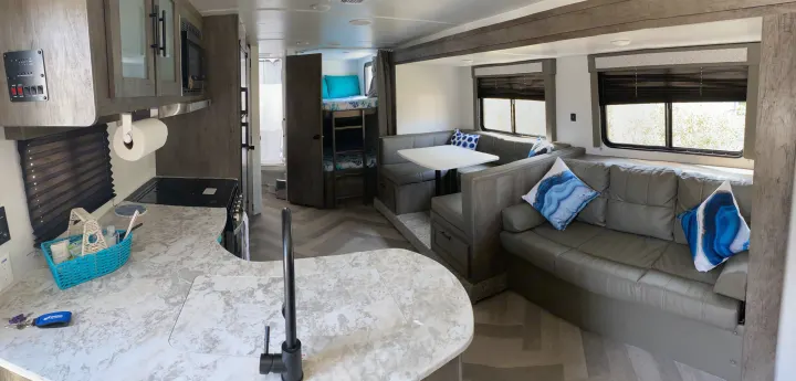 Step inside this RV rental! Modern interior with kitchen, dining booth, sofa, and bunk beds. Your perfect home on wheels awaits.. Forest River Salem Cruise Lite 2021