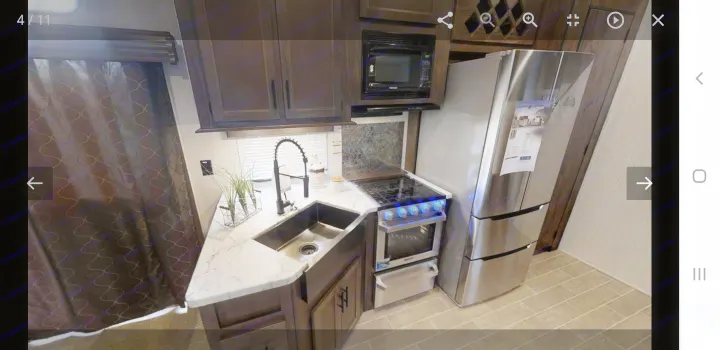 Spacious RV rental kitchen featuring a modern sink, microwave, stove, and stainless steel refrigerator. Your home on wheels.. forest river cherokee 39ca 2019