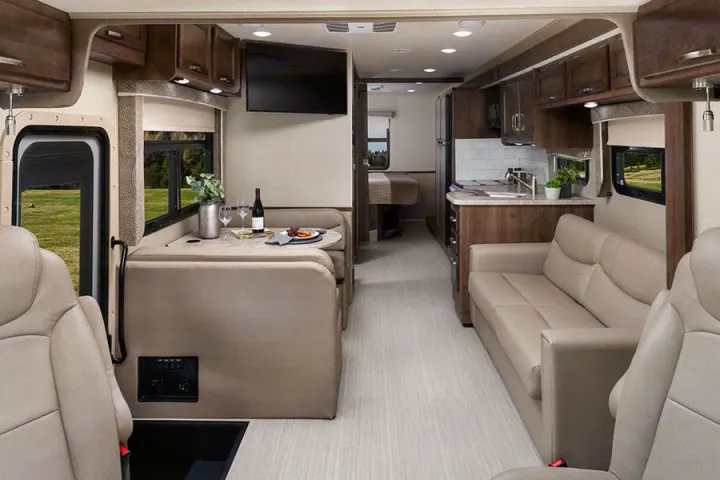 Explore this spacious rv rental interior, featuring a full kitchen, comfortable living area, dinette, and bedroom.. Entegra Coach Other 2021