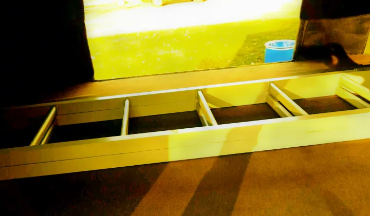 RV rental interior: Built-in ladder for bunk access, next to a sunlit window showing green grass and a blue bucket.. Dodge Grand Caravan 2014