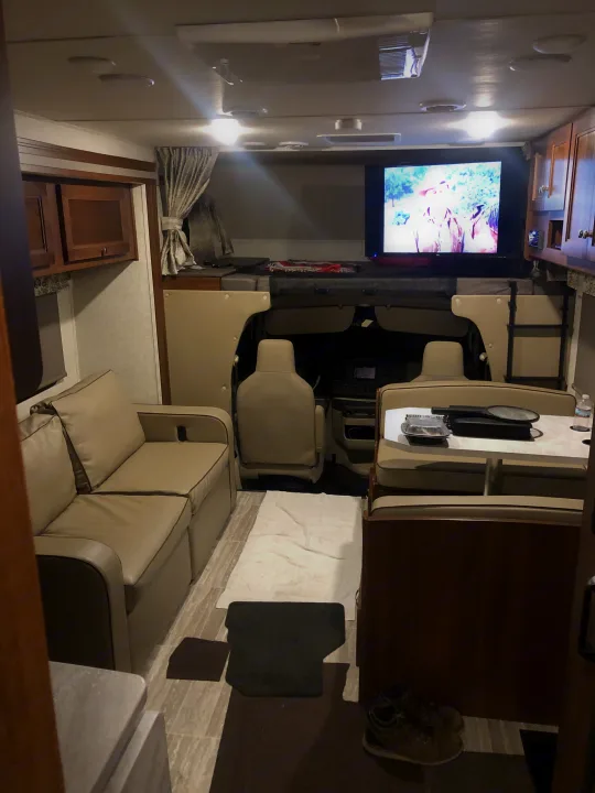 Spacious RV rental interior features a couch, dinette, and large bed over the cab.. Forest River forester 2019