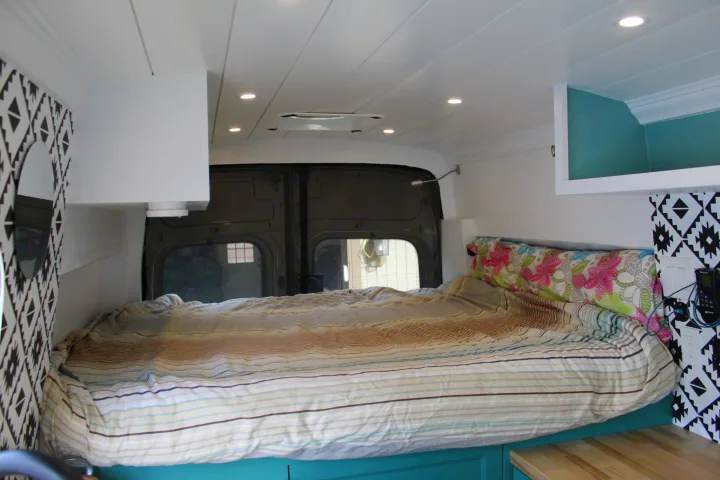 Inside this **RV rental**, find a comfy bed, modern ceiling lights, and stylish patterned accents.. Ford Transit 2020
