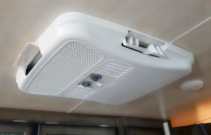 White Dometic AC unit on an RV rental ceiling. Visible are air vents, grilles, and control knobs for climate comfort.. Heartland Mallard 2019