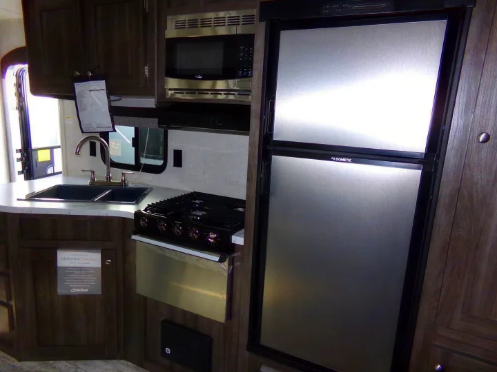 RV rental kitchen: Features compact stove, microwave, sink, and Dometic refrigerator for convenient travel.. Open Range Open Range 2020