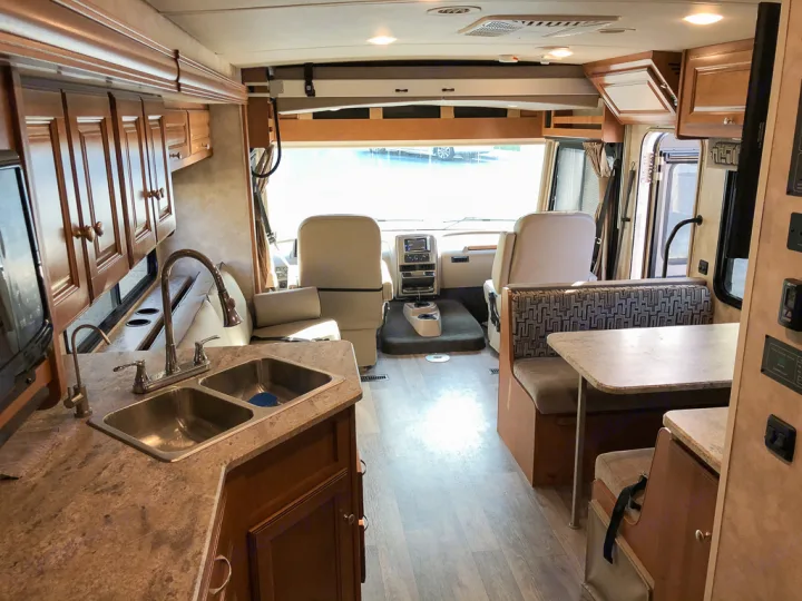Spacious RV rental interior with kitchen, dining area, and cockpit. Ready for comfortable travel and adventure.. Winnebago Vista 2018
