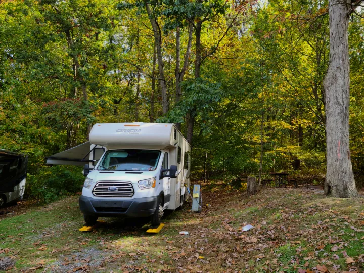 This Orion by Coachmen rv rental is perfectly set up at an autumn campsite, featuring an extended awning & leveling blocks.. Coachmen Other 2018