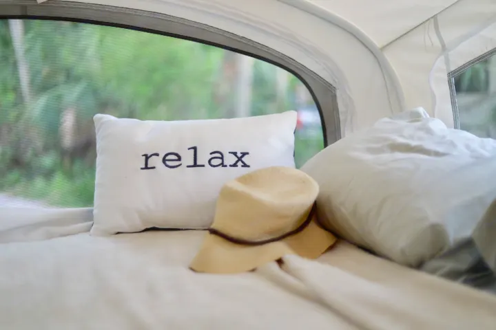 Relax in comfort! This cozy RV rental bed features a "relax" pillow and hat, with nature visible through the screen.. Starcraft Other 2018