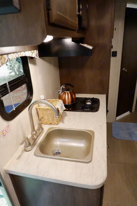 Explore this RV rental's practical kitchenette with a sink, two-burner stove, and kettle, showcasing its compact interior.. Starcraft Other 2018