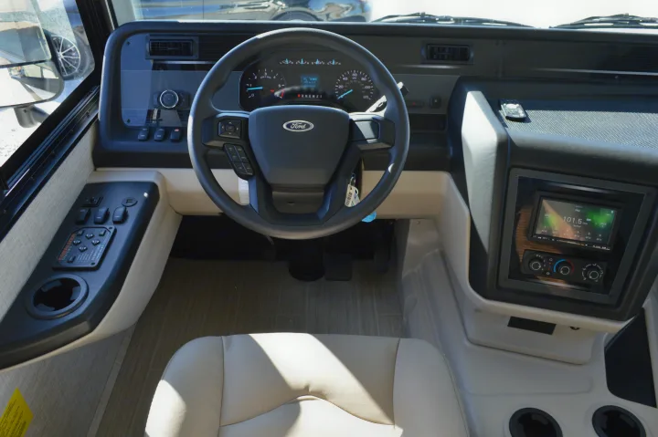 Detailed RV rental driver's cockpit showing Ford steering wheel, dashboard controls, and infotainment display.. Entegra Coach Other 2021