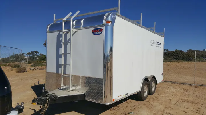 White enclosed utility trailer with a ladder and roof racks. Not an RV rental, but a sturdy cargo trailer for gear.. Complete Trailers Tool Crib Model 8.5'x16' 2016