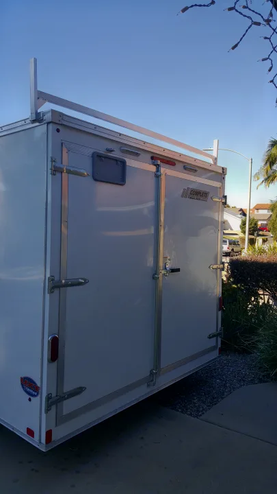White enclosed cargo trailer with roof rack & rear doors, ideal for gear on **RV rental** trips.. Complete Trailers Tool Crib Model 8.5'x16' 2016