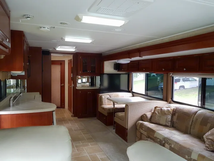 Spacious RV rental interior with kitchen, dining booth, and sofa for comfortable travels.. THOR Four Winds Infinity 2005