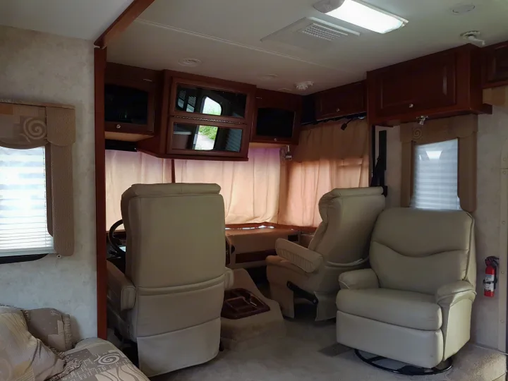 RV rental interior: comfy recliners, storage, windows, and entertainment area. Perfect for road trips.. THOR Four Winds Infinity 2005
