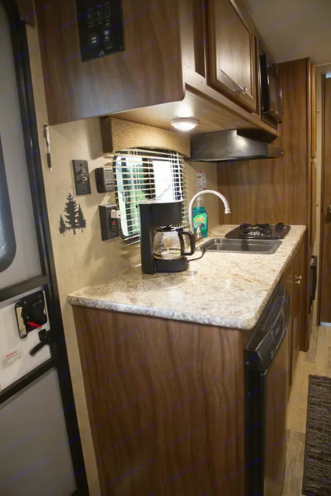 Compact RV kitchen with coffee maker, sink, stove, and microwave, perfect for your next RV rental adventure.. Forest River Other 2018