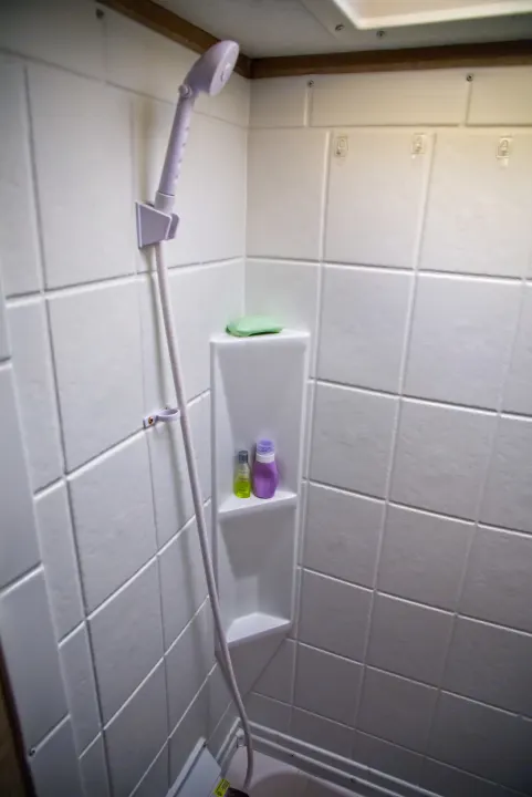 RV rental shower with handheld head, built-in shelving, soap, and bottles for a convenient clean.. Forest River Other 2018