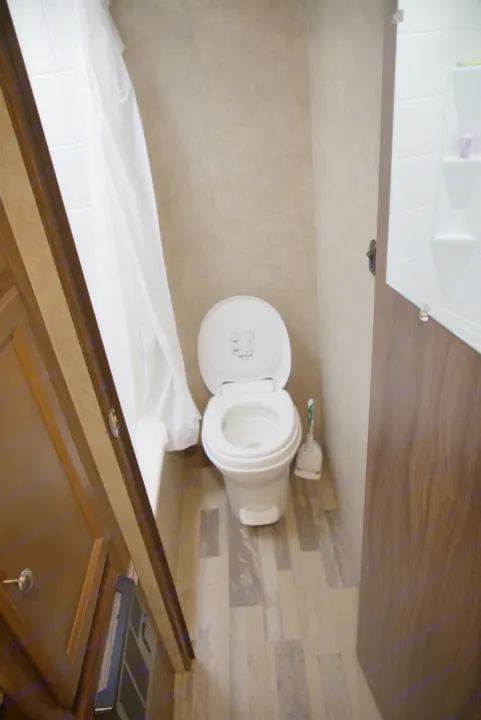 Inside an RV rental, showing a compact bathroom with toilet, shower, and patterned flooring. Ready for your next trip!. Forest River Other 2018