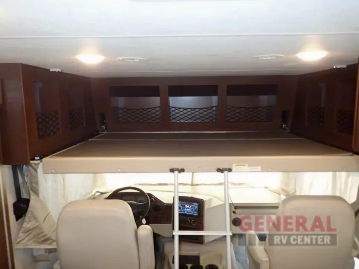 Inside an RV rental: view of the cab-over bunk bed, storage, and the cockpit with seats and dashboard. Ideal for family trips.. Other A.C.E 2020