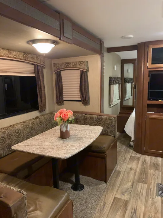Cozy RV rental interior with a spacious dinette, perfect for meals and relaxation on your next adventure.. Keystone RV Passport Elite 2017