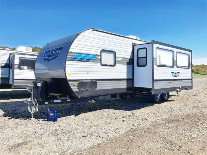 This gray and white Salem travel trailer, ideal for rv rental, showcases an extended slide-out on a sunny gravel lot.. Forest River Salem 2021