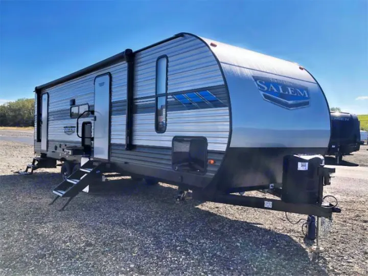Modern grey and black Salem travel trailer with steps extended, ready for your RV rental adventure on a gravel lot.. Forest River Salem 2021