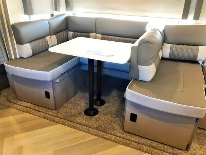 Spacious RV rental dinette: U-shaped grey and white upholstered seating, white table, and convenient under-seat storage.. Forest River Salem 2021