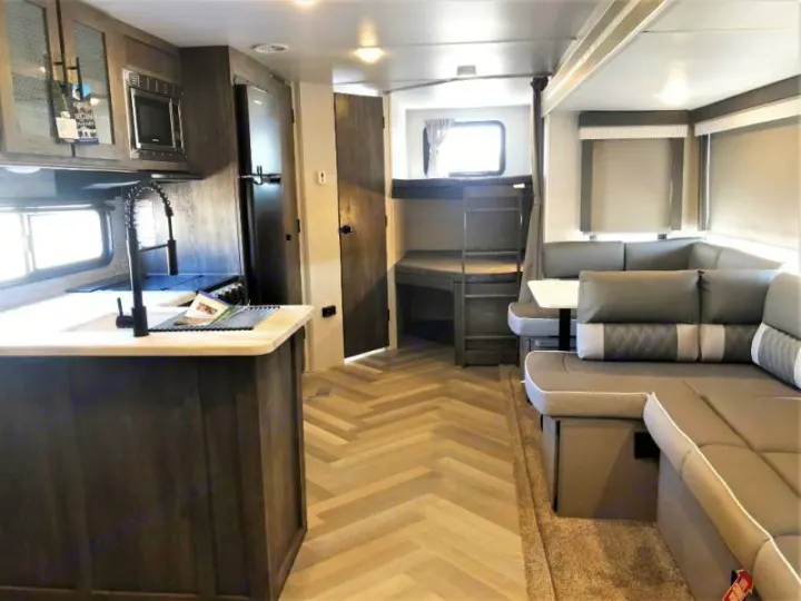 Modern rv rental interior. Features: kitchen island with sink, U-shaped dinette, and rear bunk beds.. Forest River Salem 2021