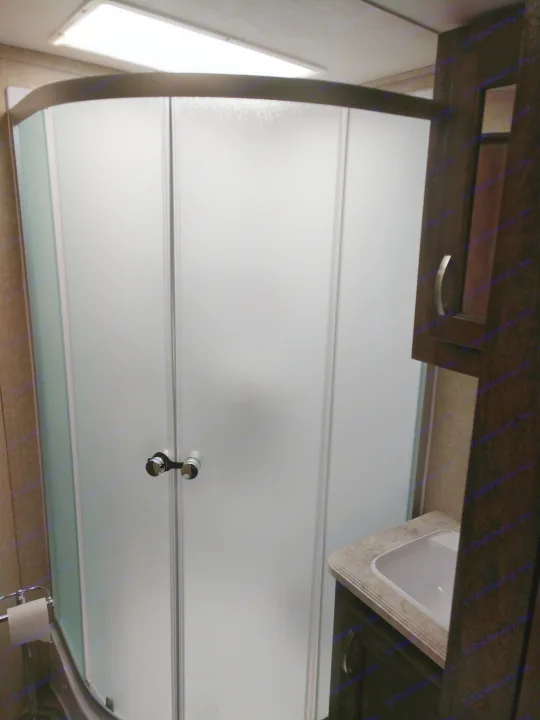 RV rental bathroom: Frosted shower enclosure, vanity with sink, and toilet paper holder. Compact design for efficient space.. Forest River Vibe 2018