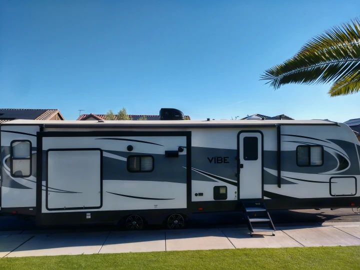 Vibe travel trailer, an RV rental option, parked with awning out on a sunny day. Ready for adventure!. Forest River Vibe 2018