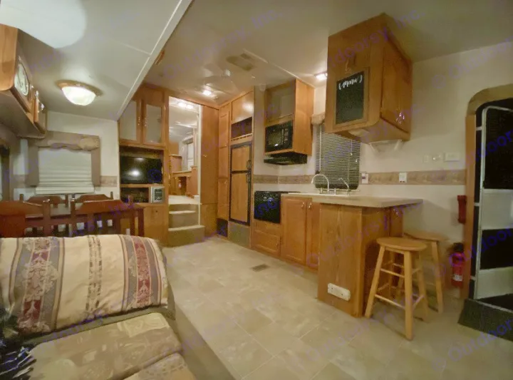 RV rental interior showing a well-equipped kitchen, dining area, and comfortable living space with wooden cabinetry.. Forest River Other 2012