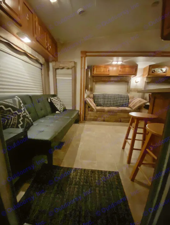Cozy RV rental interior with warm lighting, featuring a sofa, upper cabinets, and bar stools.. Forest River Other 2012