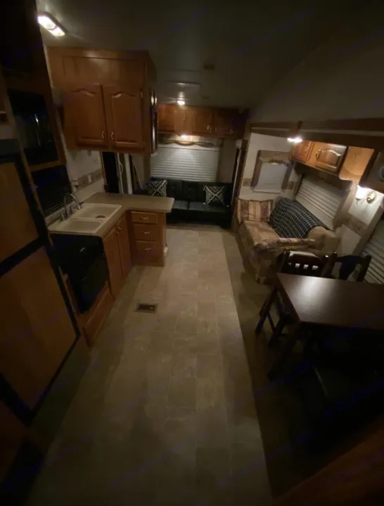 Cozy RV rental interior. View of kitchen, living area with sofa, and dining table, offering full amenities for mobile adventures.. Forest River Other 2012