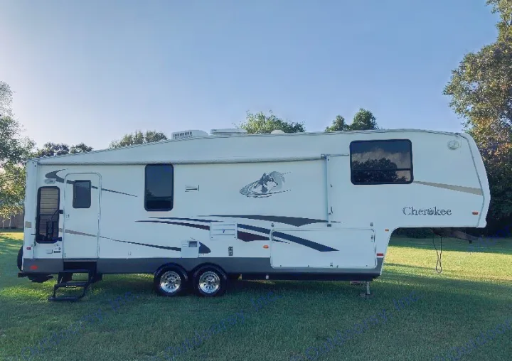 This white Cherokee fifth-wheel RV is parked on a sunny grass lawn, ideal for rv rental, camping, or travel adventures.. Forest River Other 2012