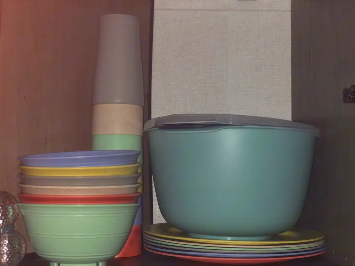 Colorful, neatly stacked kitchenware, including cups, bowls, and plates, ready for your organized RV rental adventures.. Keystone Hideout 179LHS 2021