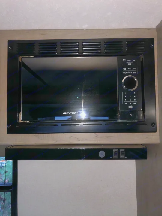 GREYSTONE microwave and range hood, common kitchen appliances found in an RV rental.. Keystone Hideout 179LHS 2021