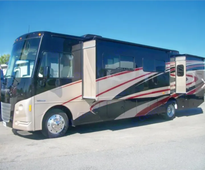 Spacious black and tan RV with extended slide-outs, ideal for your next rv rental adventure. Parked under a clear sky.. Winnebago Vista 2016