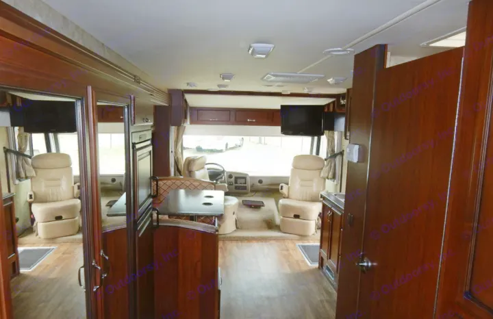 Step inside this rv rental: spacious motorhome interior featuring cockpit, leather seats, dining booth, and kitchen.. Fleetwood Storm 2013