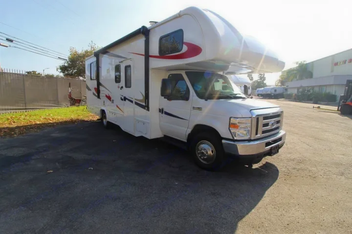 Sunlit white Class C motorhome with graphic decals, parked on asphalt, ready for your next rv rental trip.. Forest River Sunseeker 2019