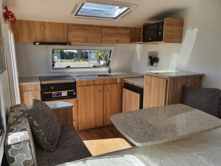 RV rental: Modern caravan interior featuring a compact kitchen with stove, sink, microwave, dining, and sleeping area.. Avan Aspire 402 2018